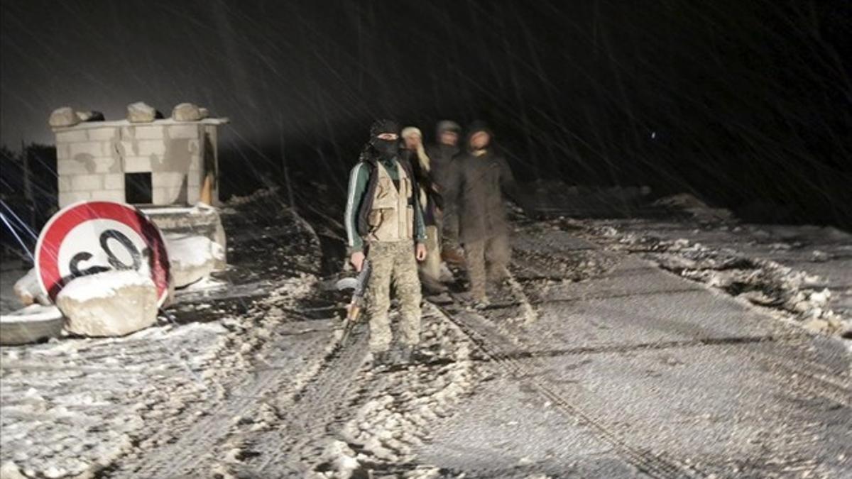 Combatientes de Ejército Sirio Libre en un puesto de control, en la provincia de Idleb, durante una tormenta de nieve.