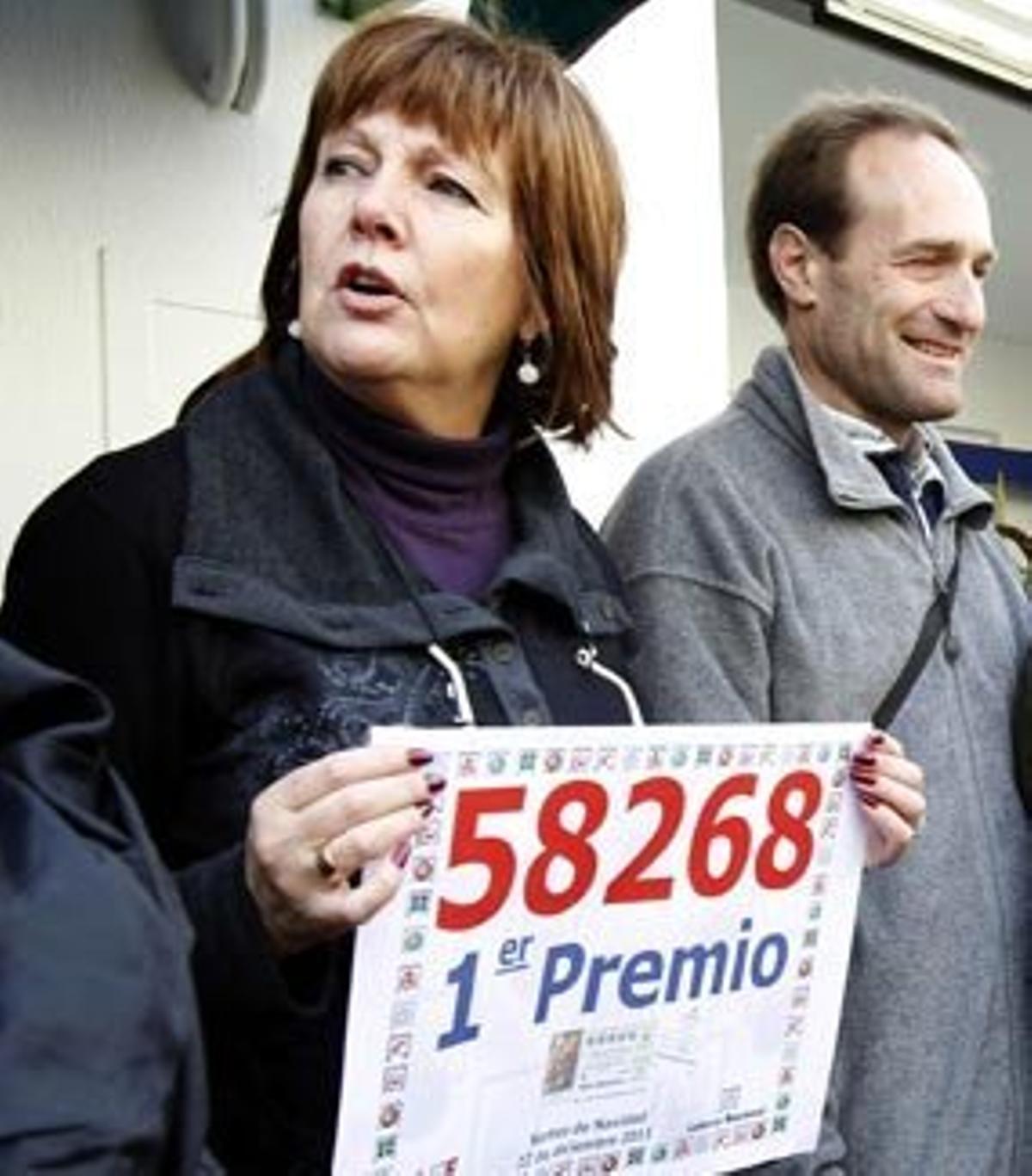 Madre de César Oriol, quien repartió el premio, posando junto al número del "Gordo más gordo" en diciembre de 2011