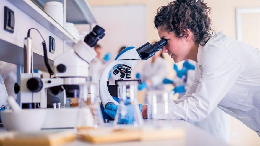 Imagen de archivo de una científica trabajando en su laboratorio con un microscopio. | EL PERIÓDICO