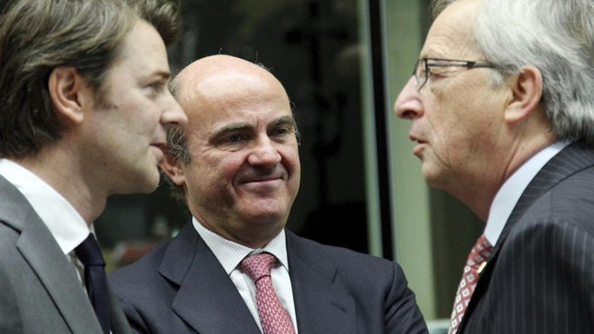 De Guindos entre el presidente del Eurogrupo, Jean-Claude Juncker (derecha) y el ministro de Finanzas francés, François Baroin.