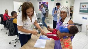 Una funcionaria de la Registraduría de Colombia durante el registro civil de un niño en el centro Intégrate, que atiende a población local y migrante de Venezuela con ayudas de USAID en Riohacha (Colombia), en agosto de 2024.
