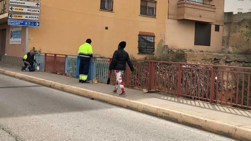 Operarios pintanto el vallado del puente.