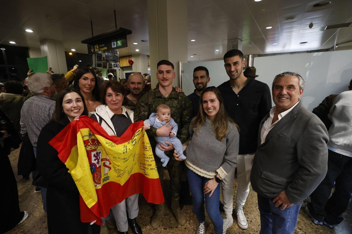 El soldado Alejandro Muñiz, con su sobrino Mauro en brazos, rodeado por su familia.