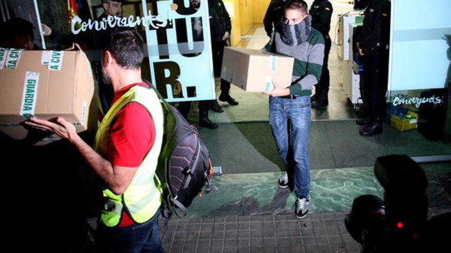 Agents de la Guàrdia Civil surten de la seu de CDC