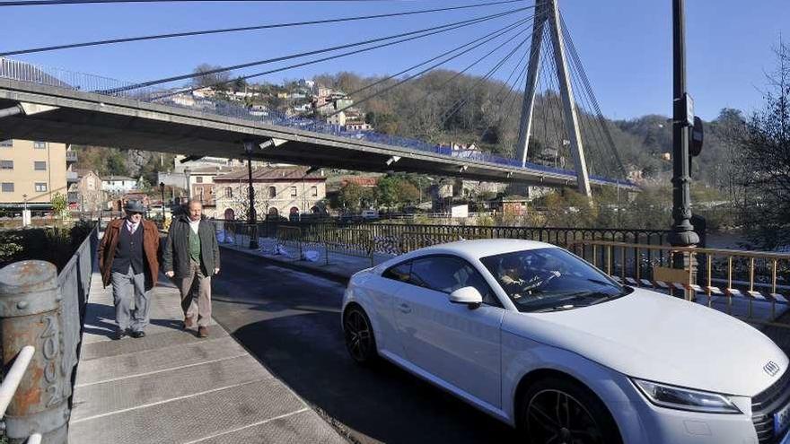 Un coche, circulando por el puente viejo de Sama ayer por la mañana.