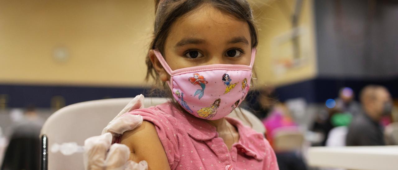 Una niña recibiendo una vacuna.