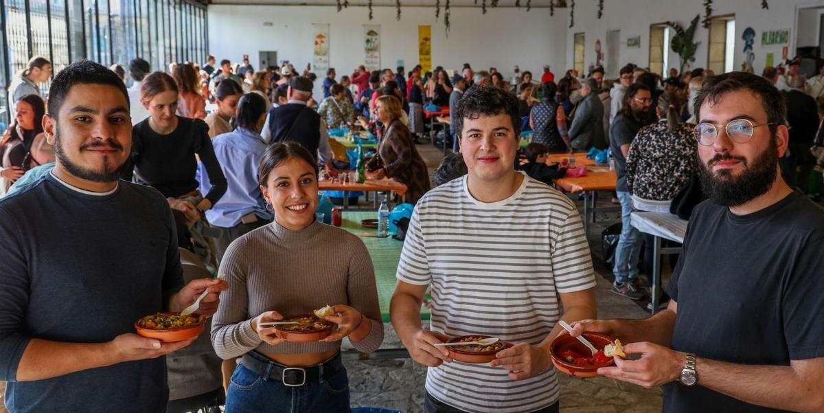 Cuatro jóvenes con platos de setas, ayer en la fiesta de A Cantarela. | Iñaki Abella