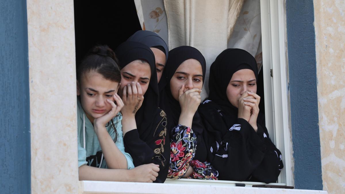 Mujeres palestinas observan desde una ventaja el funeral de un hombre muerto tras los enfrentamientos en la aldea de Saida, en Cisjordania, con tropas israelíes.