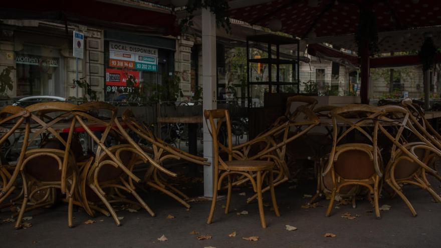 Sillas recogidas de una terraza de un bar cerrado en Barcelona.