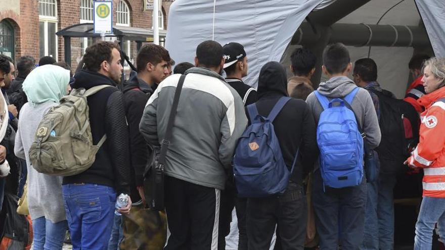 Refugiados sirios hacen cola en una tienda de campaña de la Cruz Roja para un registro médico tras llegar a Eisenhuettenstadt (Alemania).