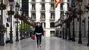 Una mujer con mascarilla recorre la calle Larios durante el segundo dÃ­a laborable del estado de alarma a causa de la pandemia del nuevo coronavirus (COVID-19). En MÃ¡laga, (AndalucÃ­a, EspaÃ±a), a 17 de marzo de 2020.