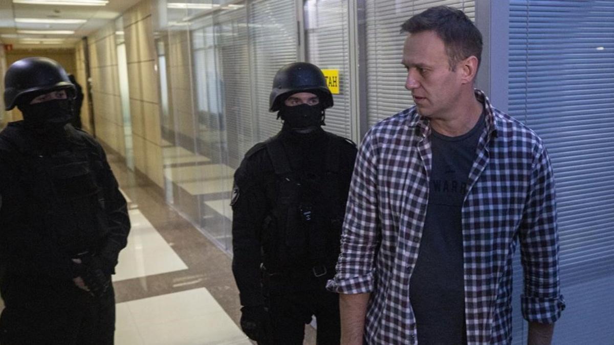 Alexei Navalni, en sus oficinas con dos policías, ayer.
