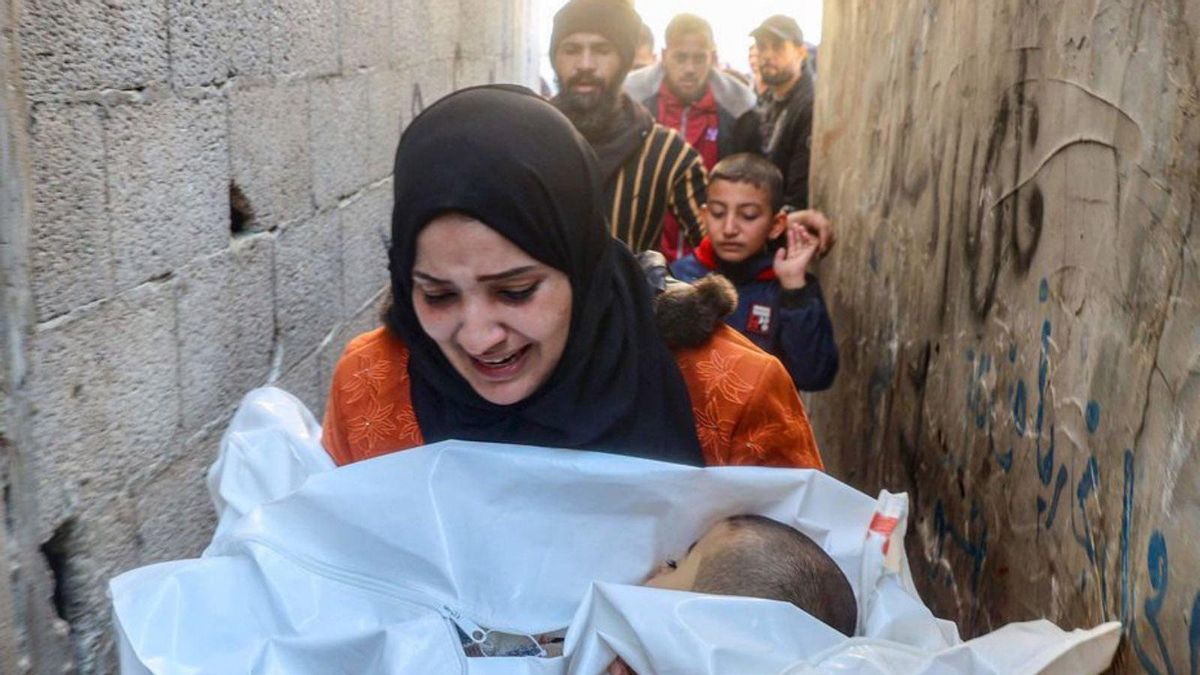 Una dona amb el cos del seu fill, que va morir després d’un atac al camp de refugiats de Nuseirat, al centre de la Franja de Gaza, ahir. | EYAD BABA / AFP Una dona amb el cos del seu fill, que va morir després d’un atac al camp de refugiats de Nuseirat, al centre de la Franja de Gaza, ahir. | EYAD BABA / AFP