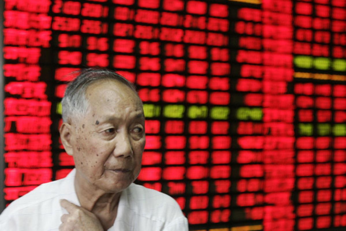 Un inversor observa el monitor de preus d’una companyia de seguretat privada a Xangai.