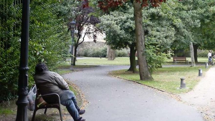 Un indigente, ayer, sentado en un banco del parque Ferrera.