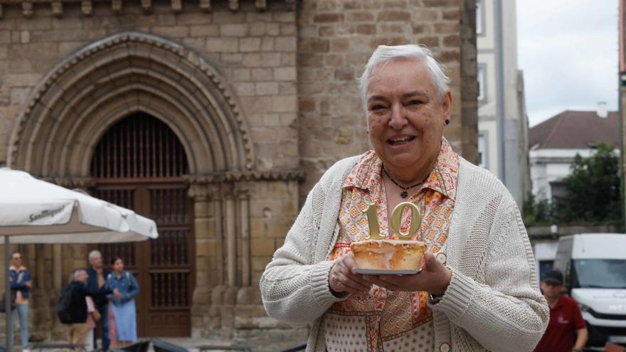 La cronista Josefa Sanz sopla las velas de un bollo mantecado delante de la iglesia vieja de Sabugo. | Mara Villamuza