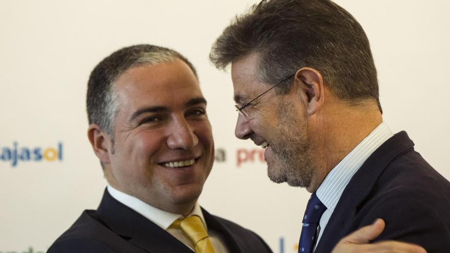 El ministro de Justicia, Rafael Catalá (d), saluda al presidente de la Diputación de Málaga, Elias Bendodo, a quien ha presentado en un desayuno informativo organizado por Europa Press en la capital malagueña.