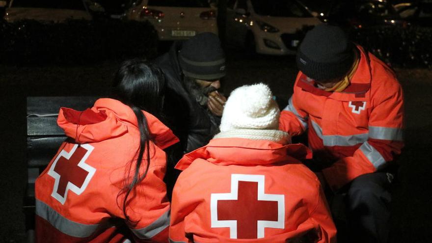 Voluntaris de la Creu Roja amb un sense sostre que sol dormir sota les vies del tren