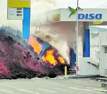 El rápido avance de la lava en el casco urbano de La Laguna hizo que en apenas unos minutos sepultara la gasolinera situada en el cruce de las carreteras que conectaban Los Llanos de Aridane con Puerto Naos y La Laguna con Tazacorte. A la izquierda, captura de un vídeo que recoge la colada norte dentro de la estación de servicios el pasado miércoles. Arriba, los bomberos del Consorcio de Gran Canaria y los miembros de la Unidad Militar de Emergencias durante la extracción del agua de los tres tanques para evitar posibles explosiones ante la previsión de que actuaran como si fueran una olla a presión. |