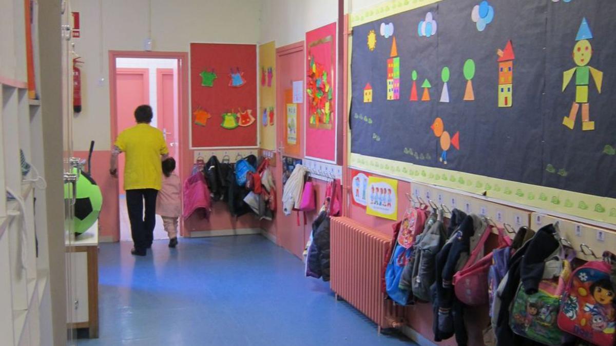 Una maestra acompaña a una niña al aula.