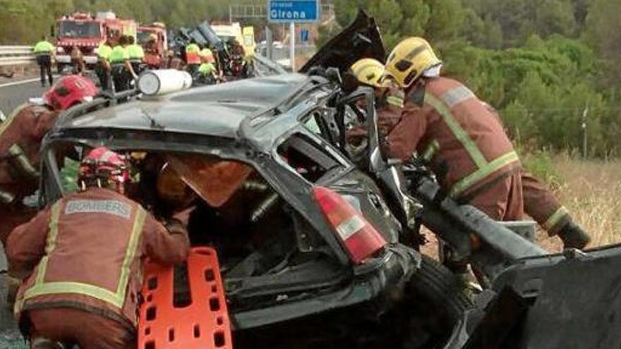 Els bombers en les tasques d&#039;alliberament dels ferits que van quedar atrapats al cotxe, ahir