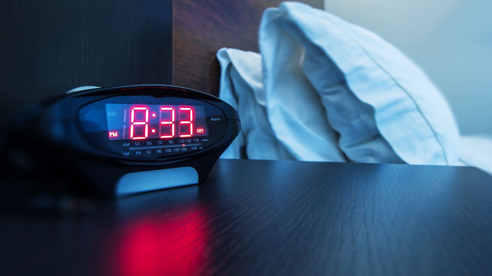 Reloj despertador sobre una mesilla de cama