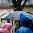 Un grupo de turistas trata de protegerse de la lluvia este jueves en San Sebastián.