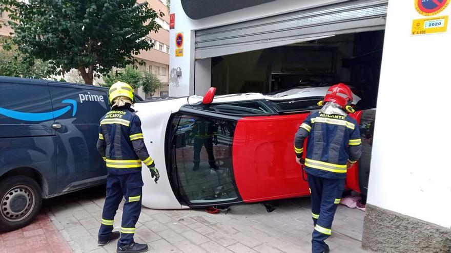 El coche semivolcado dentro del local de una empresa de interiorismo de Alicante.