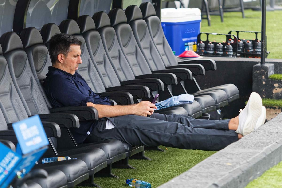 Haralabos Voulgaris, presidente del CD Castellón, consulta el teléfono en el banquillo del SkyFi Castalia.