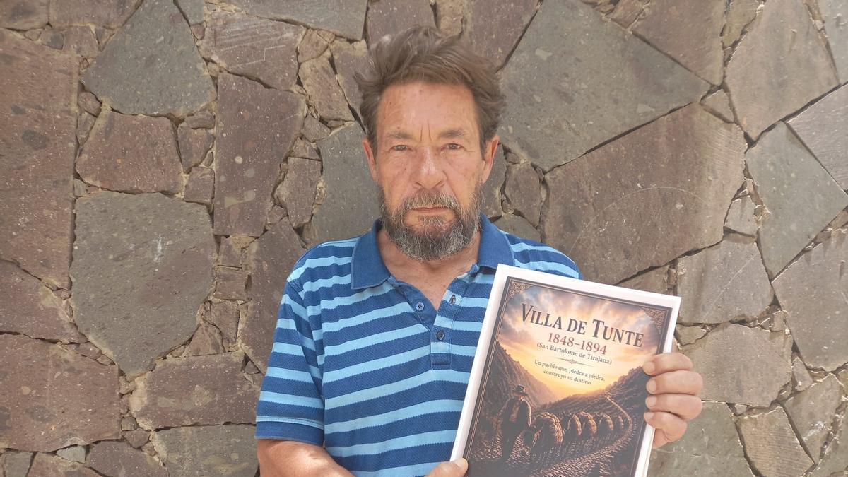 José Yánez con posando con un ejemplar de su libro.