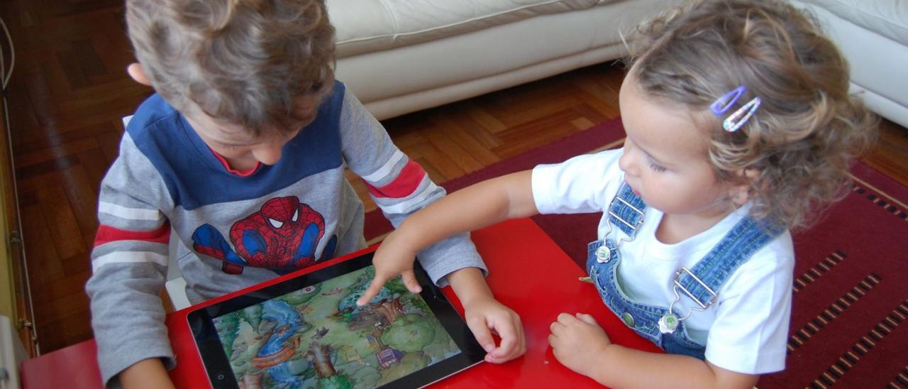 Dos niños juegan con una tablet.  | | E.D