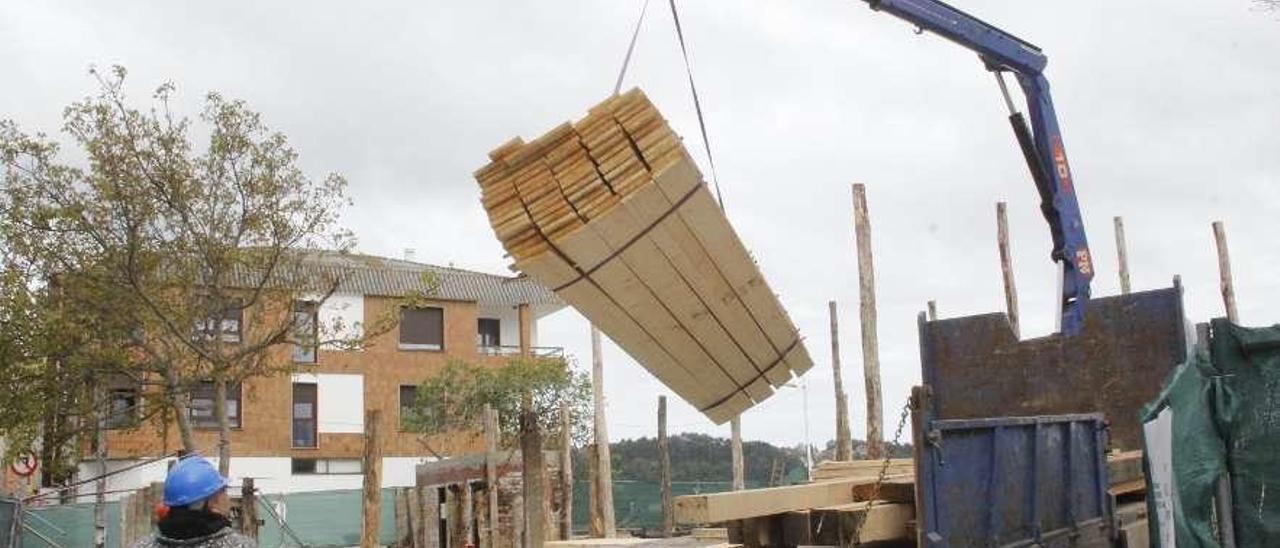 Operarios descargando madera durante las obras de rehabilitación del astillero. // Santos Álvarez