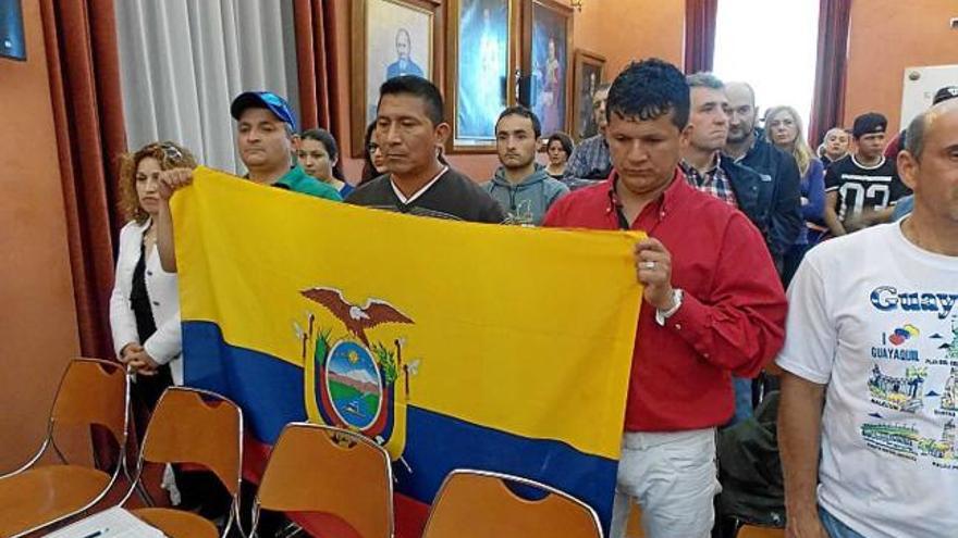 Membres de la comunitat amb una bandera del país, al saló de plens