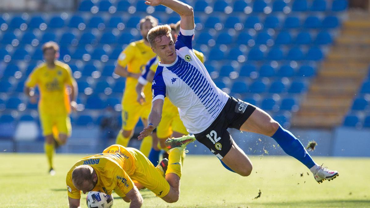 Manu Garrido, en el aire, y Badal, en el suelo, después de pugnar por el balón en una acción de ataque del Hércules.