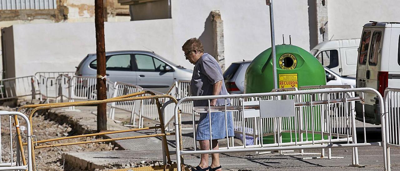 Una vecina cruza una de las zonas 
ya levantadas de la calle 
Lluís Despuig, en el Cabanyal.  eduardo ripoll