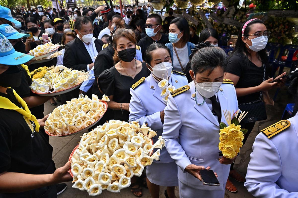 La gente observa cómo las piras funerarias incineran a 19 víctimas del tiroteo en la guardería de Uthai Suwan en el templo Wat Rat Samakee en Uthai Sawan. Un exoficial de policía disparó y mató a 37 personas, al menos 24 de ellos niños, después de irrumpir en una guardería infantil en el noreste de Tailandia.