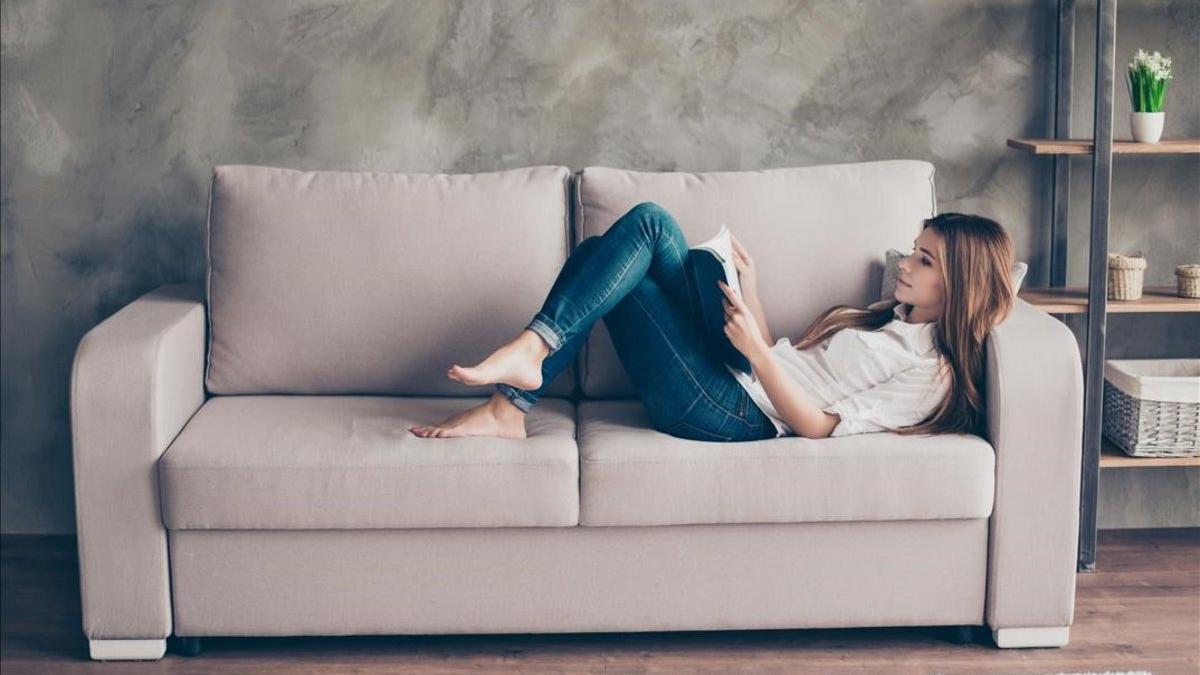 Una mujer tranquila en su casa leyendo