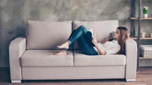 Una mujer tranquila en su casa leyendo.