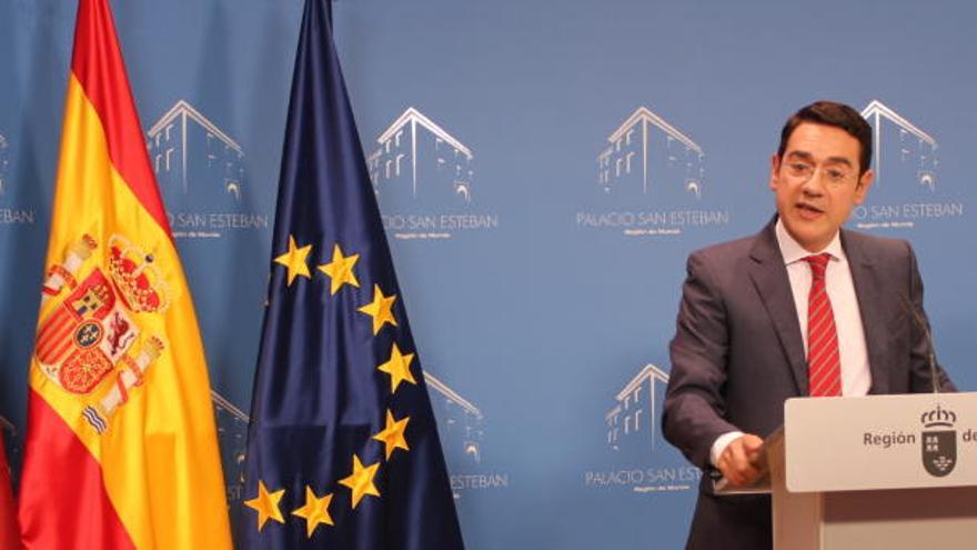 Ruiz informa de los acuerdos del Consejo de Gobierno junto a las banderas de la Región de Murcia, de España y de la Unión Europea.