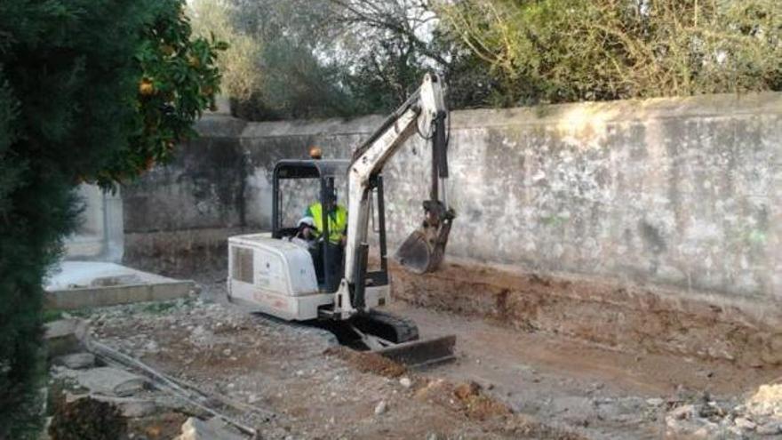 Una máquina excavadora en el cementerio.