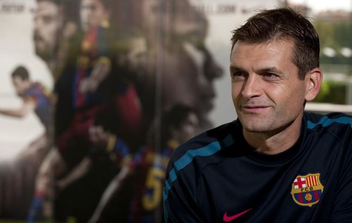 Tito Vilanova en una entrevista, amb un mural a la Ciutat Esportiva Joan Gamper.