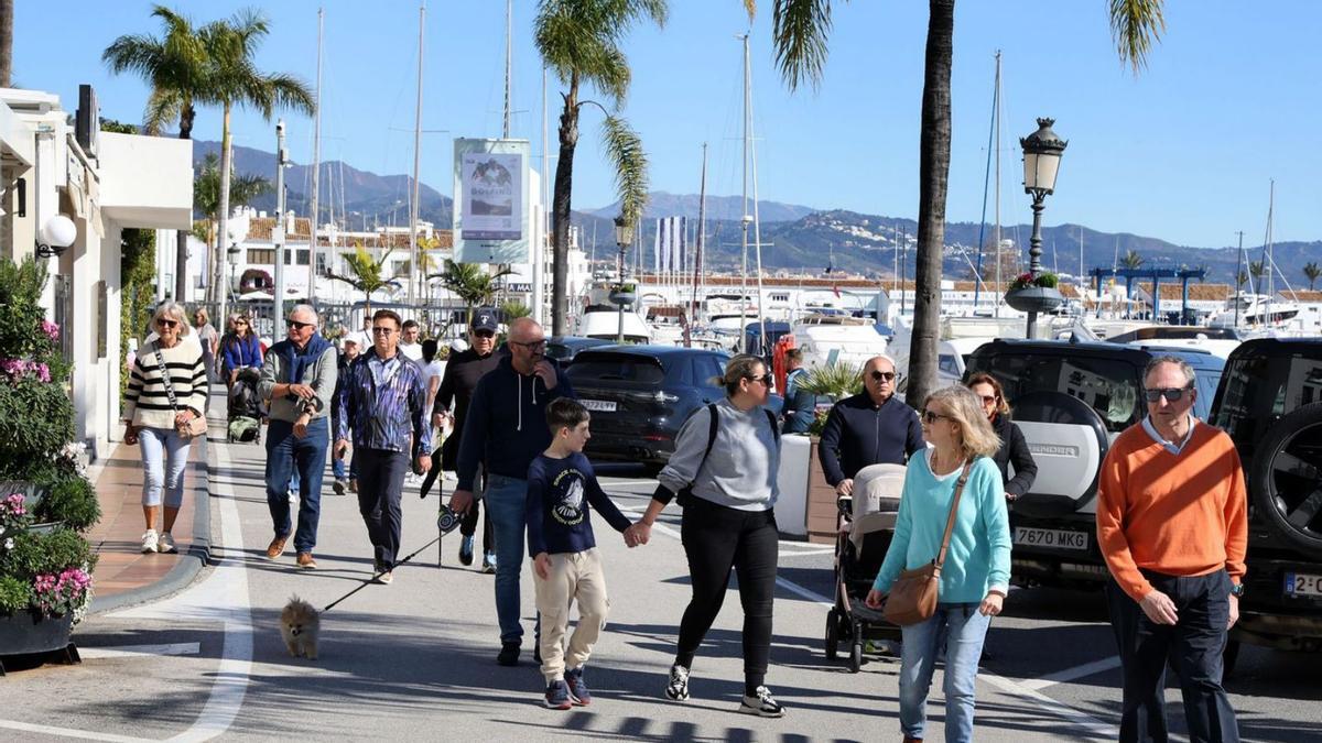 Un grupo de turistas pasea por la vía principal de Puerto Banús en febrero.