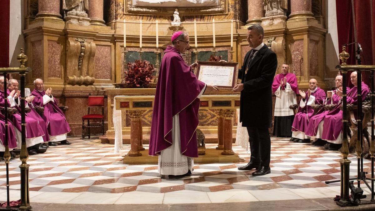 El obispo de Zamora, Fernando Valera, recibe el diploma del reconocimiento de manos del presidente de la cofradía, Fabio Antonio Martínez, en el altar mayor de la Catedral. | Ana Burrieza