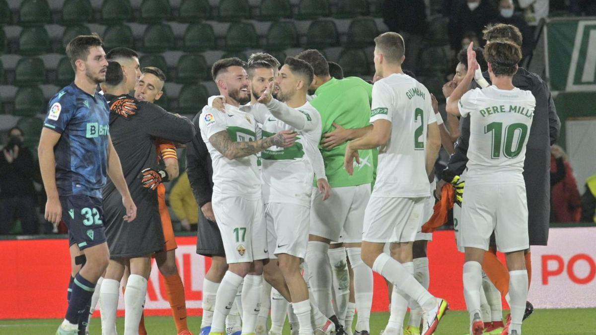 Los jugadores del Elche celebran en una piña la victoria al final del partido ante el Cádiz 