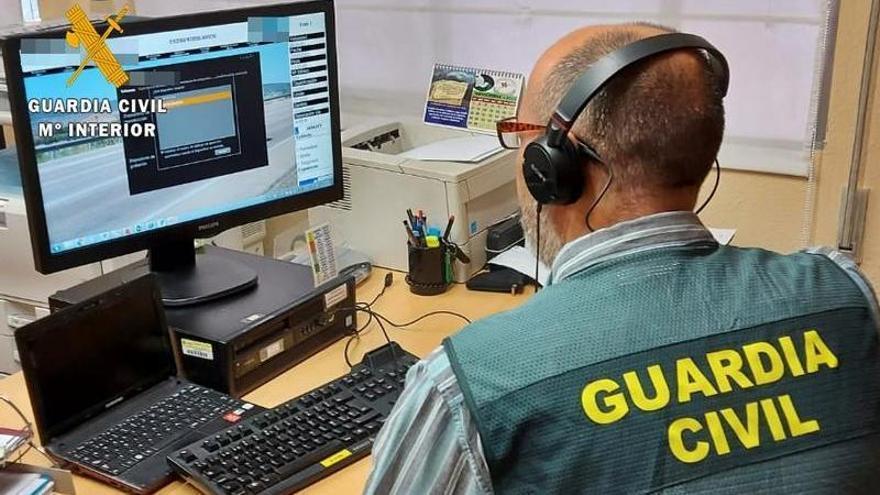 Un agente de la Guardia Civil investiga las estafas del mediador de seguros con su ordenador.