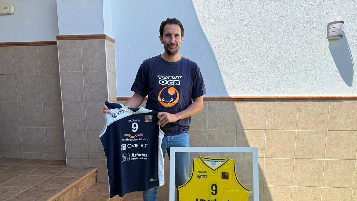 Víctor Pérez sujete la camiseta que llevó el OCB en su primer año en Oro y, enmarcada, la de la campaña 2018-19.