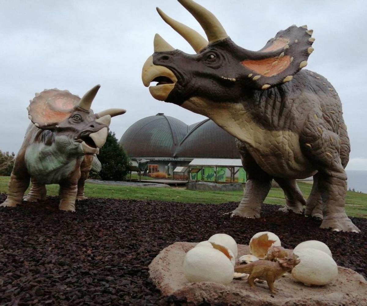 Réplicas de dinosaurios, con el edificio del MUJA al fondo. | LNE