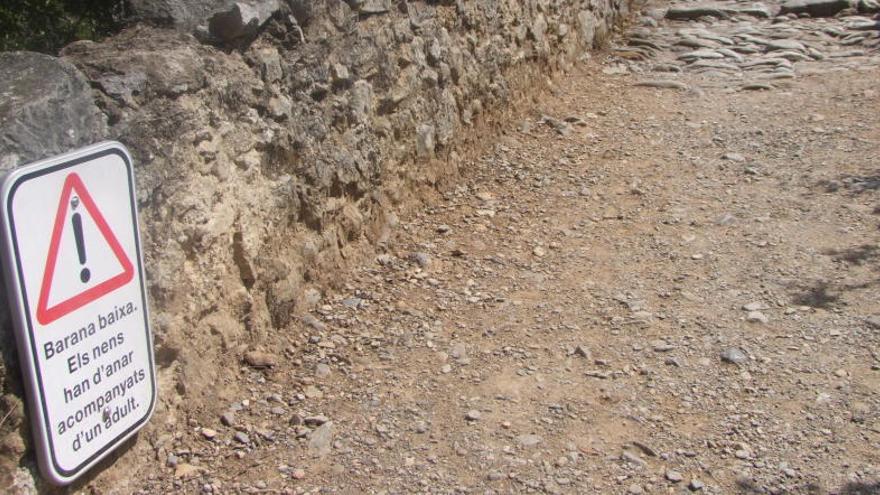 Un senyal alerta de la perillositat de travessar el pont del Llierca