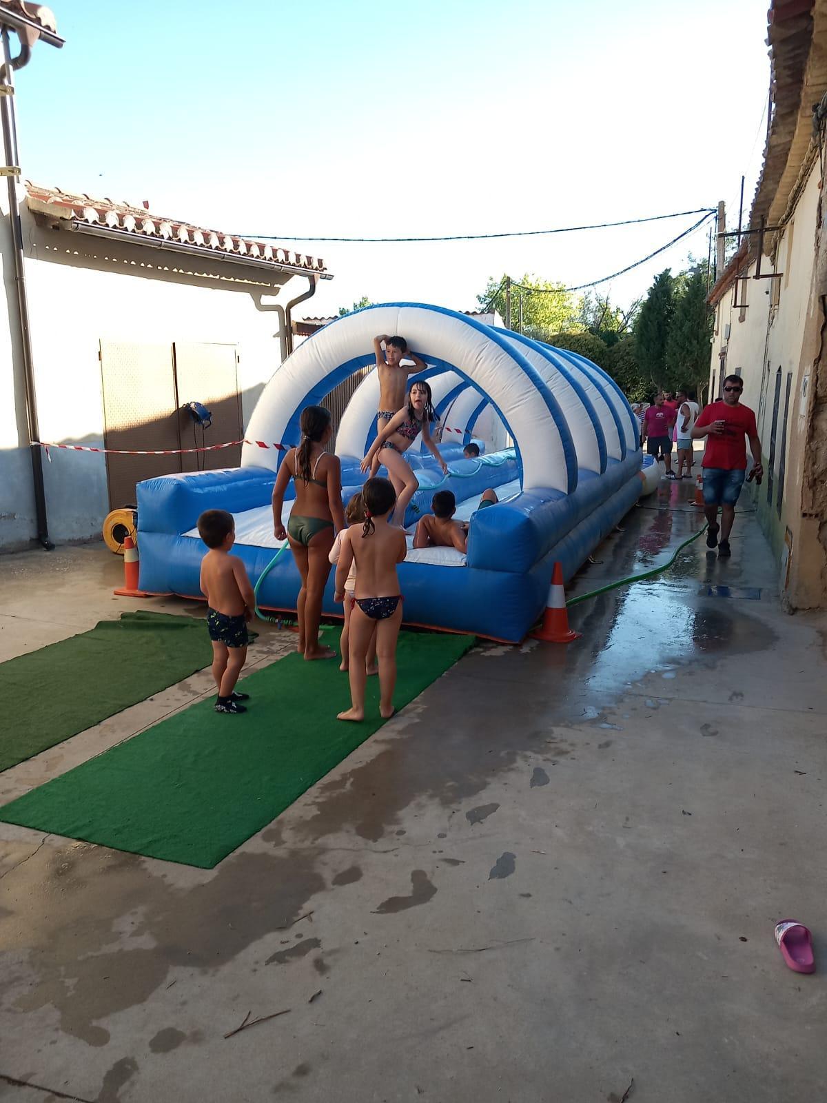 Niños disfrutan de la resbalina de agua durante las fiestas