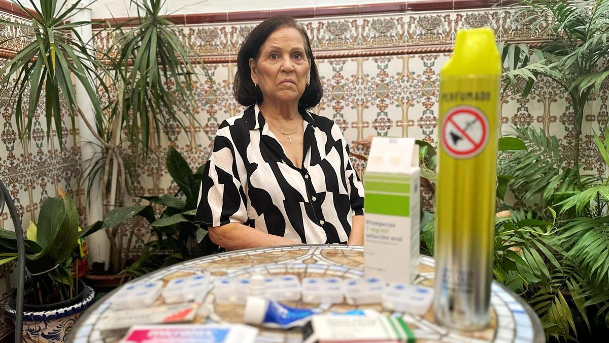 Ana García, víctima del virus del Nilo, posa en el patio interior de su casa con todos los medicamentos que tiene que tomarse en la actualidad.